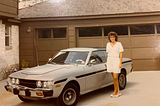 Woman standing beside her new Toyota car in 1985.