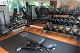 Park Hyatt Washington D.C.’s fitness center, which includes an adjustable bench, a set of dumbbells, and a leg press machine.