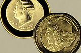 Image of two ancient coins on a surface.