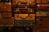 A wall of suitcases and luggage symbolising the historical and political baggage associated with “belief” and spirituality.