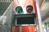 Decorative photo: Green light, red light, and a grate. In the rough shape of a face