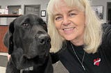 picture of a black lab and a lady with white hair, this is Cooper and Patricia
