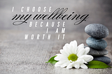 gray background with gray stones stacked on top of each other on right with white daisy lying in front of the stones. words in center: I choose my wellbeing because I am worth it