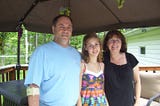 A picture of me with my parents in the 9th grade. Photo taken in the backyard on our deck. 2009