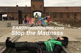 Woman lies on train tracks entering Birkinau Death Camp Blocked by Sustainies, Coaches and Ambassadors holding the SDG banner