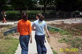 two girls walking outside, backs to camera