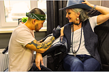 beautiful older woman getting a tattoo