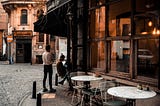 People on sidewalk outside of cafe