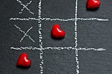 Three red hearts in a game of tic-tac-toe