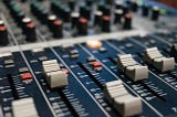 Closeup of slider knobs on an audio mixing desk.