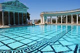Image showing a large palace with marble columns and a massive swimming pool.