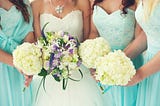 bride and bridesmaids standing in a line with their boquets