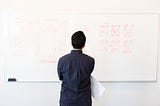 Designer standing at a whiteboard thinking about how a flow is going to work within an app