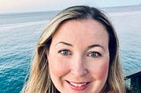 picture of author smiling with the ocean in the background