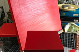 a canvas painted red sits on an easel