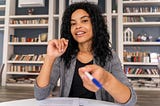 Woman in a library taking notes from books