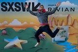 The author Federico Francioni jumping in front of a SXSW 2025 banner