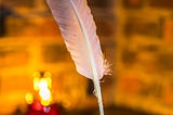 A quill pen in front of a warmly lit but out of focus background