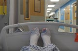 View of my feet in a hospital bed, wearing surgical stockings with one big toe poking out