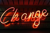 a red neon sign that says change