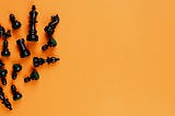image of black chess pawns laying in an orange background
