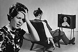Black and white image of woman frustrated over husband mindlessly viewing television