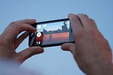 Hands holding up smartphone to record video