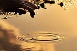 Reflection of hand on water body