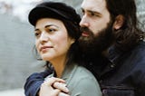 Couple, embrace, love affection, he has a beard and wears a jacket, she wears a hat and a jacket