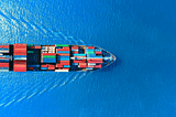 A cargo ship with loaded containers on Travelling overs the Sea