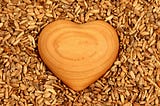 Wooden heart on seeds, showing love and kindness to everyone we meet