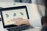A woman pointing at a dataviz on a laptop
