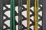 4 capoeira belts ranging from green to green and yellow in order of level.