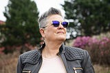 Older woman in a black leather jacket and sunglasses