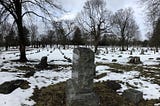 panorama view of granite headstones in snow-covered ground all in rows