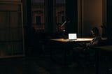 Man working late at his desk, all alone, looking tired. It shows the negative effect of the Hustle Culture.
