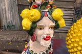 A Sicilian ceramic vase of a woman’s head with a moustache and lemons