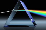 Picture of a rainbow shining through a prism against a black background.