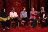 Rosie attempting to explain her prize task as the rest of the cast look on.