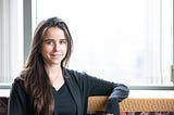 Maria De-Arteaga, McCombs School of Business and Good Systems researcher, stands next to a brightly lit window.