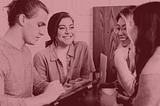 Four people standing around a table, smiling
