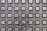 a metal array or grid of squares. it is worn and weathered.