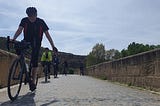 Riders on a bicycle crossing a bridge