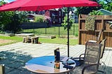 Outside table and chair with shade umbrella and computer on table