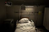 Empty hospital bed in dim lighting