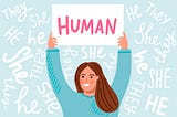 Woman holding up a sign that says “Human” while the background says “She, He, They”