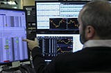 Man uses financial trading software to monitor stocks patterns.