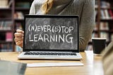 Picture of woman holding laptop that reads “never stop learning”