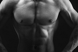 Black and white photo of a man’s naked abs