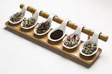 A range of six different artisanal teas on a set of white spoons by Rujani Tea